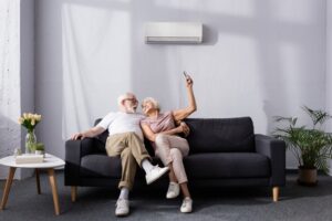 couple-on-couch-enjoying-temperature-control-with-a-mini-split-air-handler