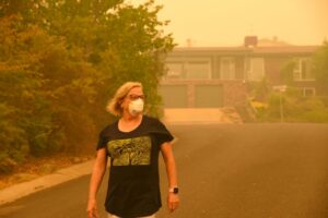 person-wearing-a-mask-walking-through-a-haze-of-wildfire-smoke